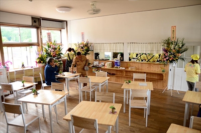 カフェはら笑の店内。木のテーブルと椅子が並ぶ明るい教室