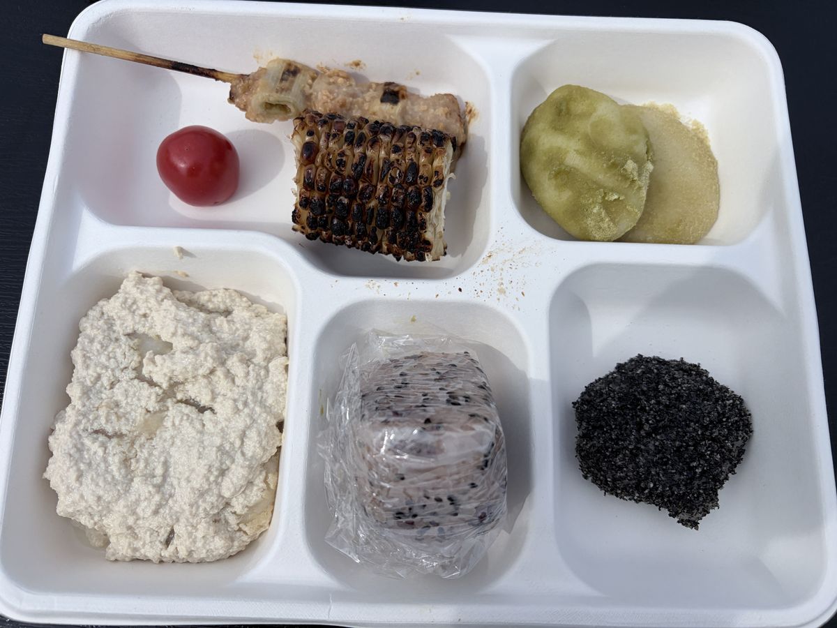 つきたてのお餅3種、お赤飯、焼き鳥、焼きトウモロコシ、キュウリの一本漬けが盛られたワンプレート
